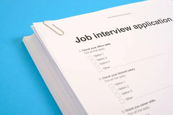 Stack di CV e domanda di lavoro su blue desk — Foto Stock