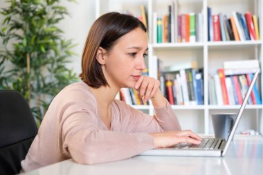 kişisel bilgisayar önünde masada oturan kız