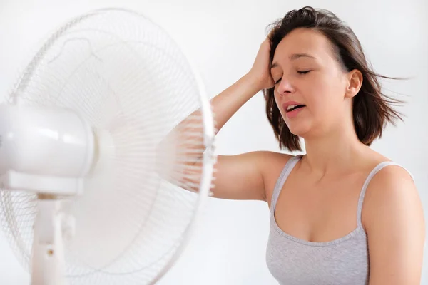 Mujer refrescante delante de un ventilador eléctrico ventilador —  Fotos de Stock