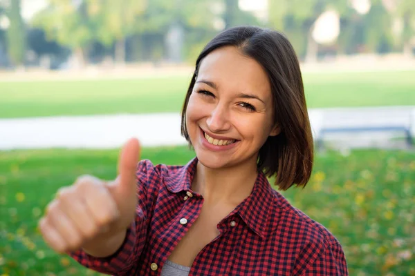 Mujer pulgar hacia arriba haciendo gestos y sonriendo mirando a la cámara —  Fotos de Stock