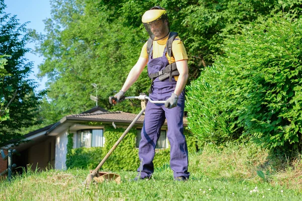 Professionele tuinman met behulp van een rand trimmer in huis Tuin — Stockfoto