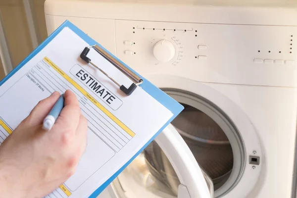 Worker estimating cost for broken washing machine