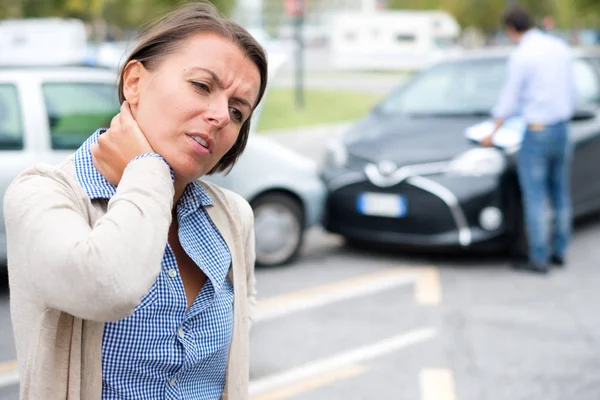 路上で車がクラッシュした後の女性の首を傷つける — ストック写真