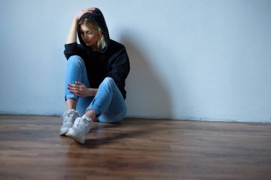 Genç kız yüzünü kapüşonlu sweatshirt b izole altında gizleme