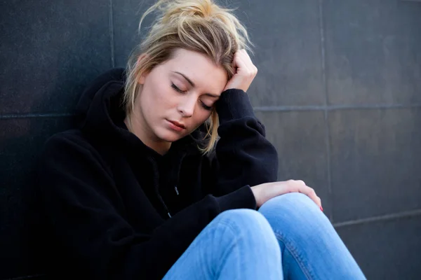 Alone and sad girl portrait on black wall — Stock Photo, Image