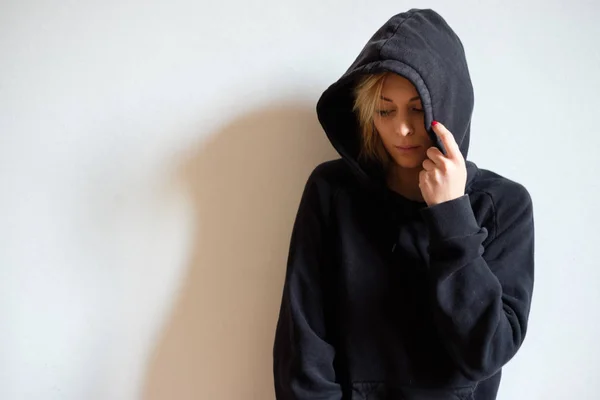 Сумна дівчина-підліток з чорним светром з капюшоном ізольована — стокове фото
