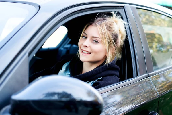 Fille gaie conduisant sa nouvelle voiture prête à partir — Photo