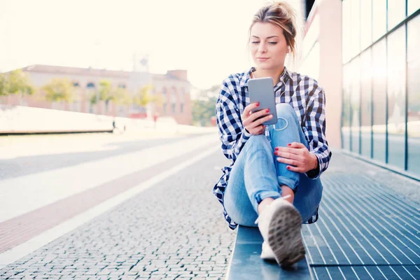 Chica viendo su pantalla de teléfono inteligente en el contexto urbano — Foto de Stock