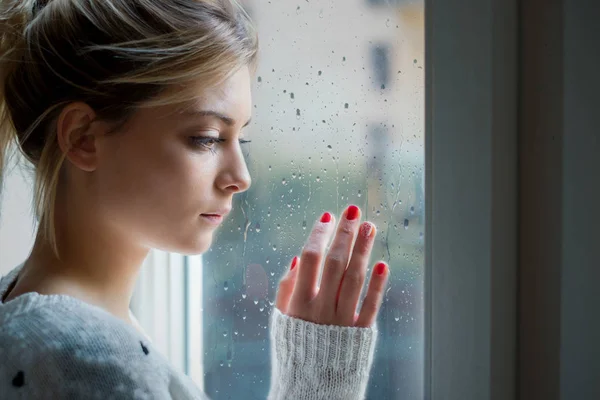 Bezorgd en alleen meisje naast het venster licht — Stockfoto