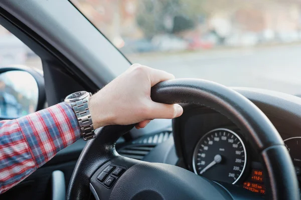 La mano en el volante de un hombre conduciendo su coche — Foto de Stock