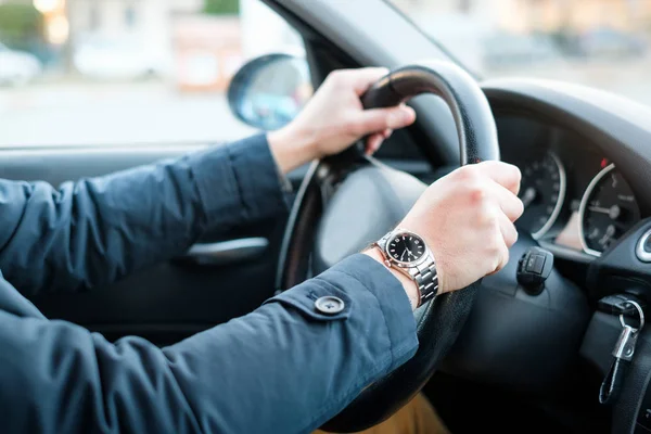 Manos en el volante de un conductor de coche nuevo — Foto de Stock