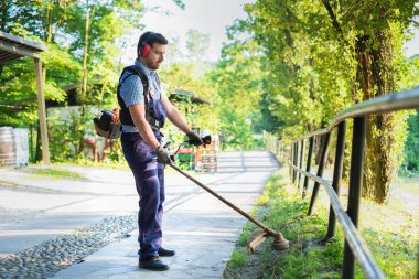 Profesyonel bahçıvan ev bahçesinde bir kenar düzeltici kullanarak