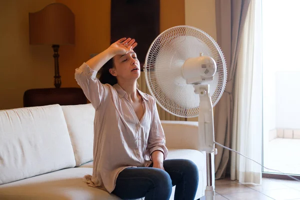 Jeune femme se détendre sous le ventilateur à la maison — Photo