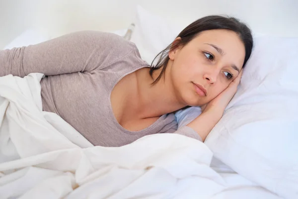 Mulher sentindo-se doente com a cabeça na cama travesseiro — Fotografia de Stock