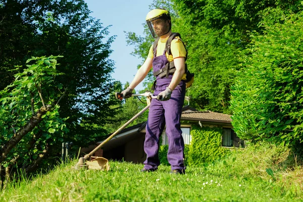 Professionele tuinman met behulp van een rand trimmer in huis Tuin — Stockfoto