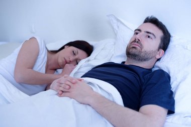 Üzgün ve depresyonda adam karısı yatakta yatan