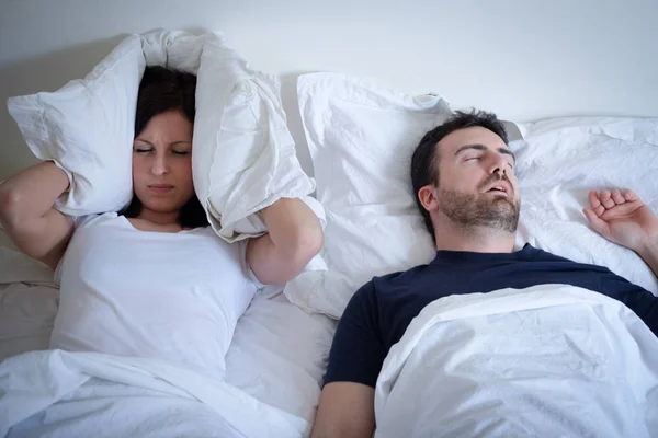 Cansada e irritada mulher de seu namorado roncando na cama — Fotografia de Stock