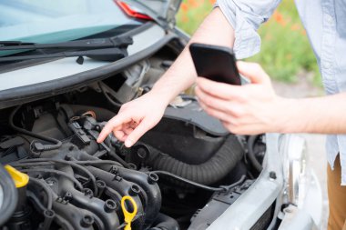 Adam cep telefonu ile ilgili yardım arıyor. Yolda araba aşağı kırık. Seyahat sorunu.