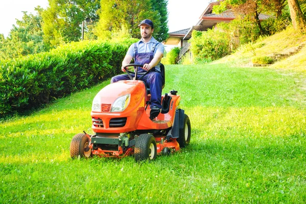 庭師の庭で乗馬の芝刈機を運転 — ストック写真