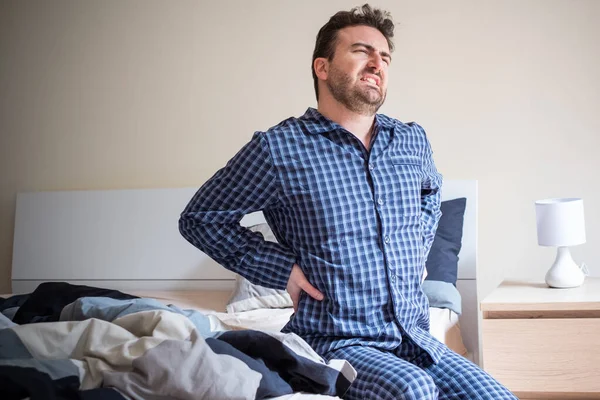 Hombre sintiéndose cansado en la mañana después de dormir en la cama —  Fotos de Stock