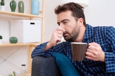 Kanepede uzanmış hasta bir adam var.