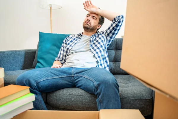 Junger müder Mann nach Umzug von großen Kisten umgeben — Stockfoto