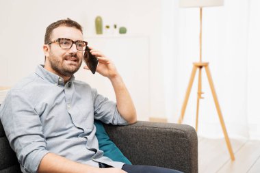 Evden cep telefonuyla konuşan adam.