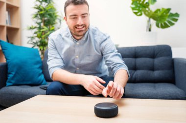 Ev asistanı bluetooth hoparlörü kullanan adam