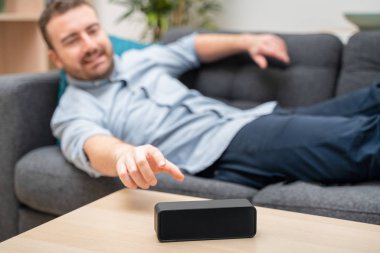 Ev asistanı bluetooth hoparlörü kullanan adam