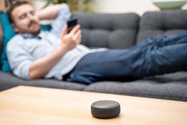 Ev asistanı bluetooth hoparlörü kullanan adam