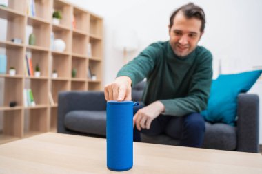 Evde sanal asistan ve akıllı konuşmacı kullanan adam