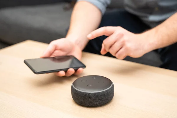 Hombre usando altavoz bluetooth asistente en casa — Foto de Stock