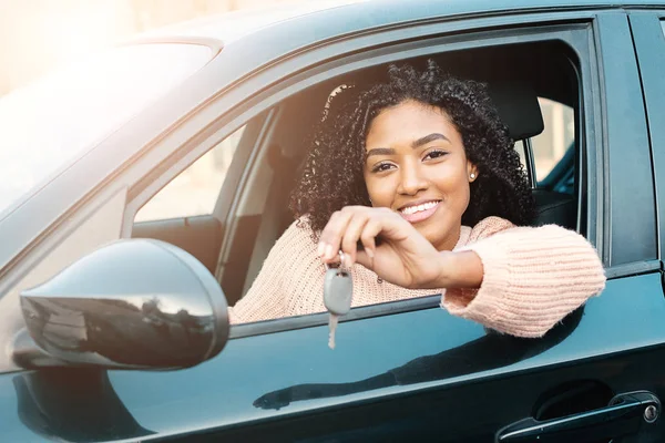 Mulher negra segurando chaves para carro novo e sorrindo para a câmera — Fotografia de Stock