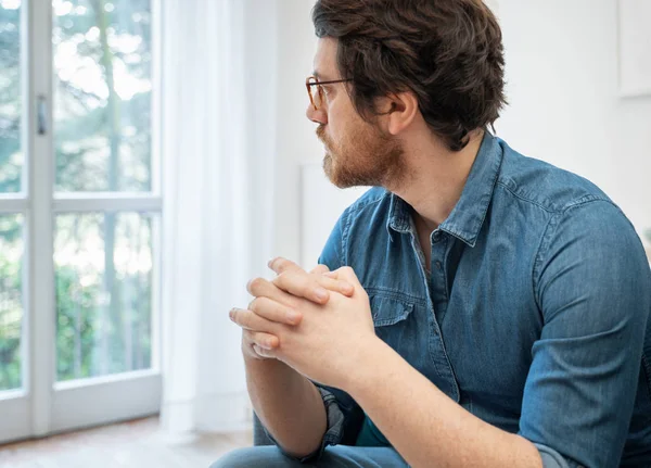 Nachdenklich ernster Mann sitzt zu Hause auf dem Sofa — Stockfoto