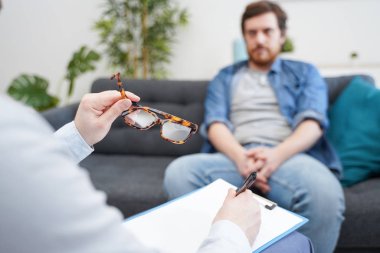 Psikolog doktor psikoterapi seansı sırasında not alıyor.