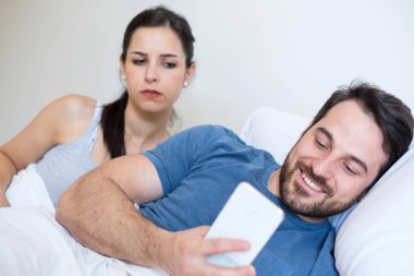 Erkek arkadaşının cep telefonundan mesaj okumaya çalışan şüpheli bir kız.