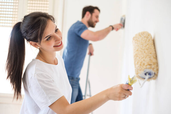 Smiling loving couple doing home renovations together