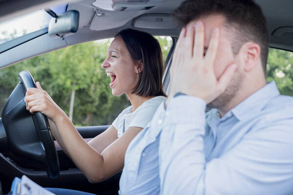 Instructor of driving school giving exam while sitting in car