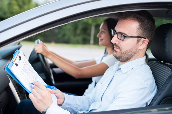 Instructor and young female student, driving lesson