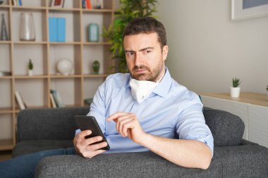 Evde Coronavirus salgını hakkında kötü haberler okuyan endişeli bir adam var.