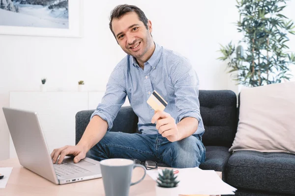 Man shopping and banking from home using credit card