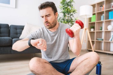 Akıllı saat kullanan biri. Genç adam akıllı kaset eğitim veri uygulamasını izliyor