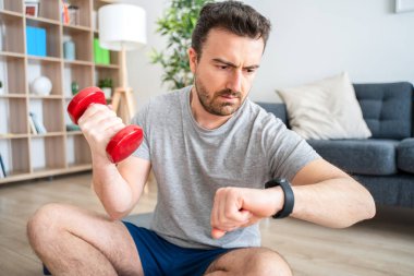 Akıllı saat kullanan biri. Genç adam akıllı kaset eğitim veri uygulamasını izliyor