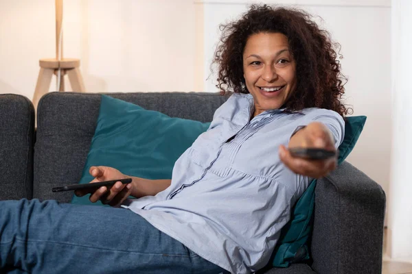 Portrait of black woman watching tv at home