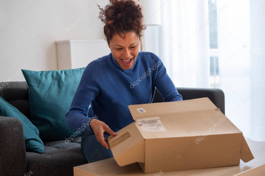Black woman portrait unboxing package after delivery