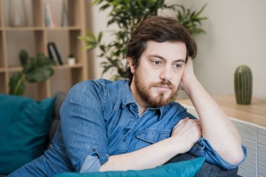 Evdeki ciddi erkek portresi şüpheli ve kafası karışık.