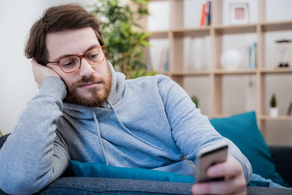 Samotny Mężczyzna Sprawdzający Telefon Komórkowy Kanapie — Zdjęcie stockowe