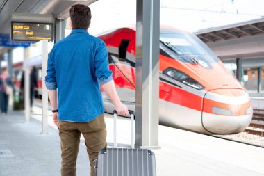 Tekerlekli sandalyedeki adam tren istasyonunda trene biniyor.