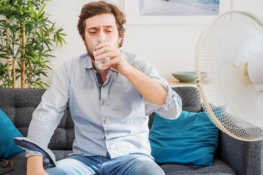 Sıcak yaz boyunca tazelemeye çalışan bir adam.