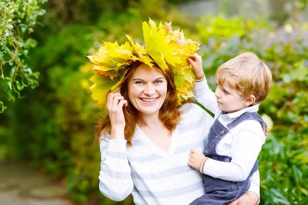 어머니 와 단풍 잎 화환 들고 작은 유아 소년 에 autu — 스톡 사진